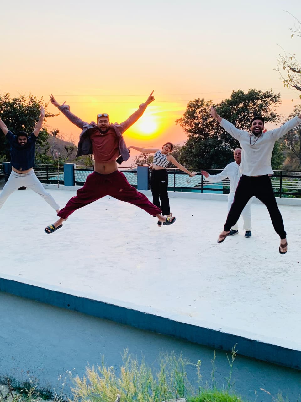 A joyful yoga group at sunset in the hills